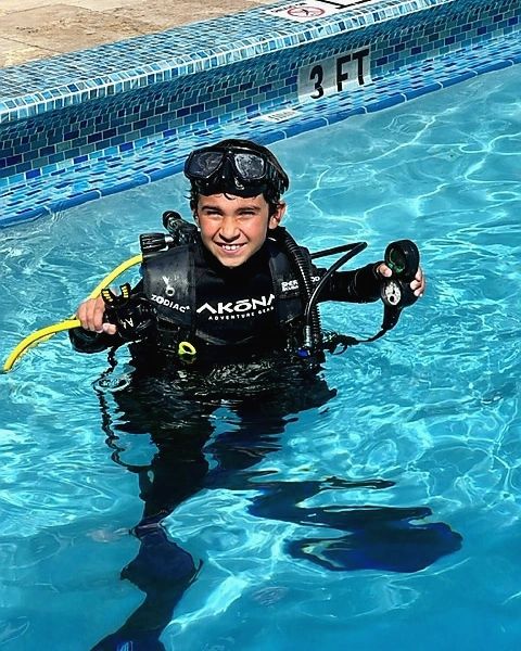 Young boy learning scuba diving in the pool